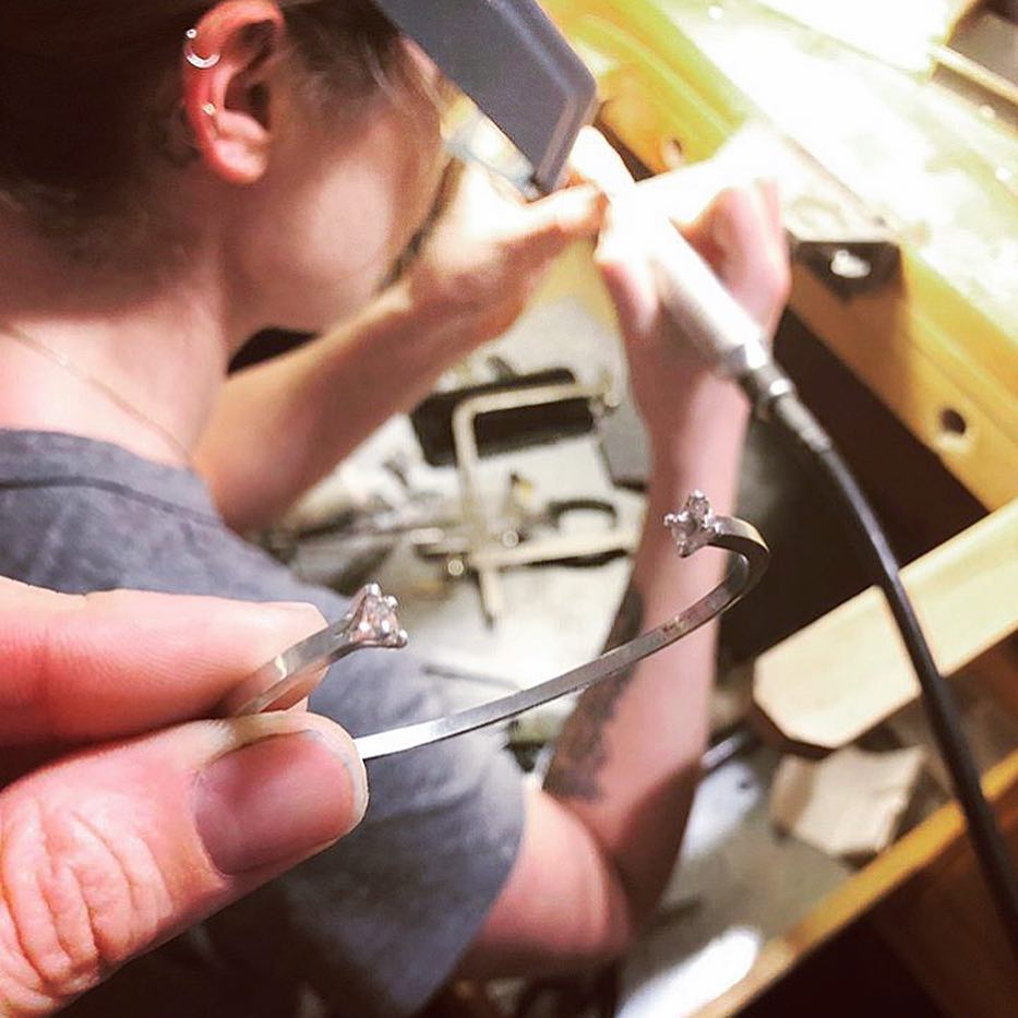 Maura Dolphin setting stones in an open cuff bracelet